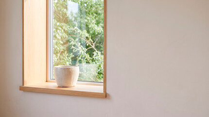 Fototapeta premium Empty ceramic flower pot on a sunlit windowsill, concept of indoor gardening preparation and minimalist home design