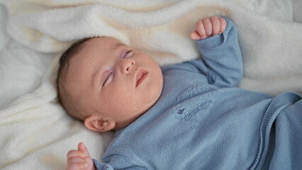 Newborn hispanic boy sleeping on soft white blanket in cradle with hand curled near face in building  serenity. © Krakenimages.com