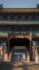 Fototapeta premium Children Running Up Steps to Traditional Chinese Temple Gate