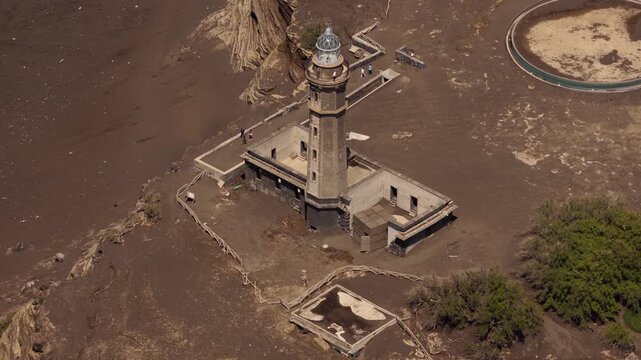 Aerial view of the historic Capelinhos lighthouse surrounded by volcanic ash landscape in Capelo, Azores, Portugal.