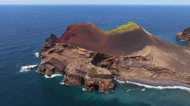 Aerial view of the Capelinhos volcano featuring dramatic volcanic cliffs and rugged terrain surrounded by the Atlantic Ocean in Capelo, Azores, Portugal.