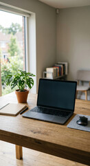 Fototapeta premium Home office desk technology details with laptop by a plant, home office desk setup showing mouse, window light and simple wooden surface