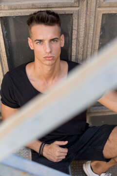 Serious young man posing in sunlight outdoors