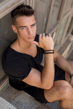 Serious young man posing in sunlight outdoors