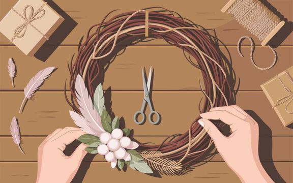 Hands crafting a beautiful floral wreath on a wooden table with scissors and gifts
