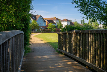 A modern housing development in Mersham, Surrey, UK. A path over a small wooden bridge leads to the houses. © Jonathan Wilson