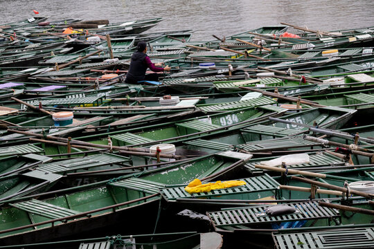 Vietrnamese woman inside traditional boats on Ngo Dong River in Tam Coc, Ninh Binh, Vietnam
