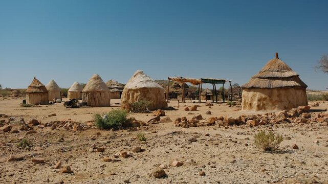 Traditional himba village with huts standing in the arid namibia landscape near spitzkoppe mountain