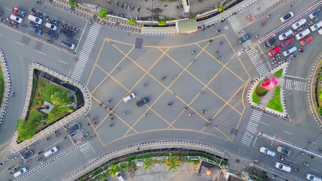 Aerial view of the busy Jalan Letnan Jendral Suprapto intersection with vehicles moving through yellow box junctions in Kecamatan Samarinda Ulu, Kalimantan Timur, Indonesia.
