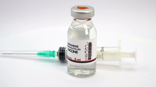 Japanese encephalitis JE vaccine development close up shot with scientific syringe inside medical biotechnology laboratory in 4K Ultra HD footage.
