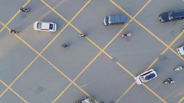 Aerial view of motorcycles and cars navigating a yellow grid intersection on Jalan Letnan Jendral Suprapto in Kecamatan Samarinda Ulu, Kalimantan Timur, Indonesia.