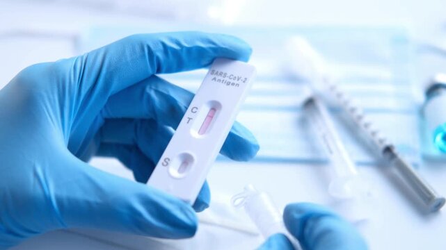 COVID 19 test medical research close up shot with unrecognizable scientist analyzing coronavirus rapid antigen sample vial in 4K Ultra HD footage.
