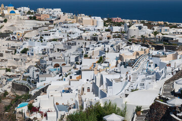 Panoramic view of Santorini’s white buildings and blue sea under clear summer light in Greece. © Andrei Tomas