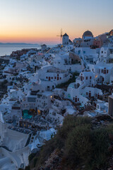 Whitewashed houses and windmill overlooking the Aegean Sea at twilight on Santorini island, Greece. © Andrei Tomas