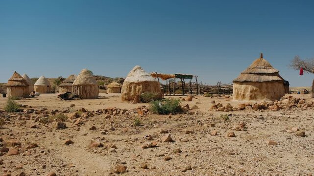 Traditional himba village with huts made of mud and straw in the arid landscape of namibia, africa
