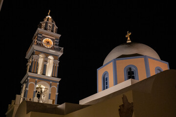 Night view of whitewashed Greek church with blue dome and cross against dark sky on Santorini island. © Andrei Tomas