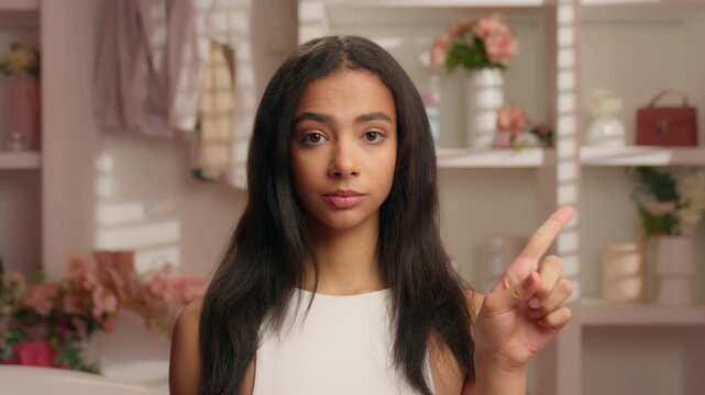 Ethnic Hispanic Latina woman shaking finger no not never wrong ethnic girl unhappy American ethnicity female looking at camera reject refuse answer restrict in pink bathroom beauty skincare trouble