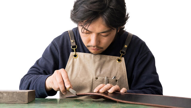 Skilled Asian Leather Craftsman Cutting Premium Leather with Skiving Knife Isolated on Transparent Background