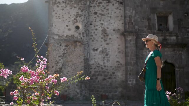 Happy woman strolls in the garden at sunrise near San Javier Mission in Baja California Sur, discovering beauty and joy in nature