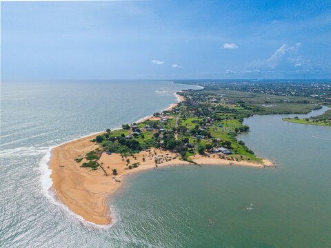 Aerial view of a coastal peninsula with sandy beaches, lush vegetation, and houses situated between the Atlantic Ocean and a lagoon in Monrovia, Montserrado, Liberia.