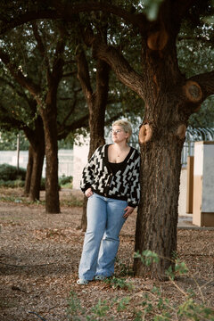 portrait of a young woman leaning on a tree