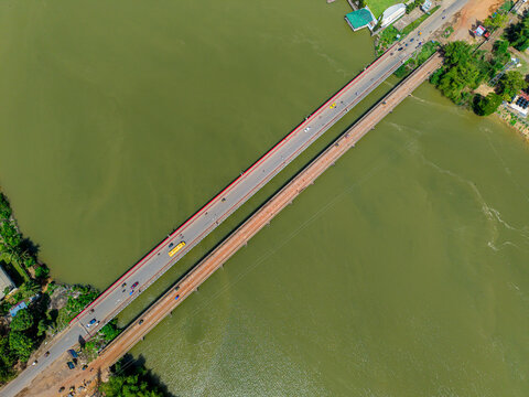 Aerial view of a bridge spanning a wide river with vehicles driving across and lush green vegetation along the banks in Monrovia, Montserrado, Liberia.