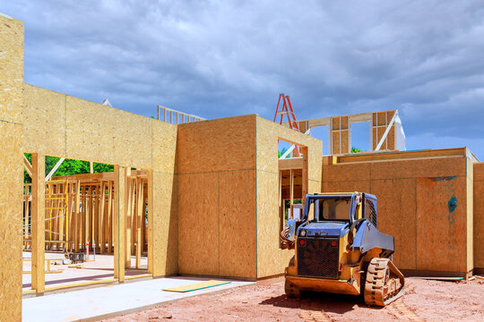 Workers build new beams structure at construction site with machines wooden frames
