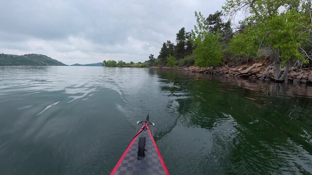 stern POV from a kayak - paddling on Horsetooth Reservoir in Fort Collins, Colorado, cloudy summer morning scenery 