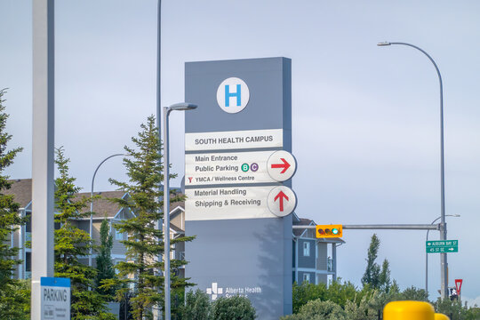 Calgary, Alberta, Canada. June 25, 2026. Eye-level view of a grey South Health Campus hospital directional sign under a bright day sky.