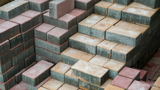 Rows of multicolored concrete paving blocks stacked on the ground