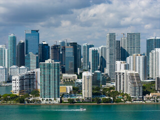 Obraz premium Miami skyline with blue sky clouds. Miami aerial city view with downtown. Miami coastal cityscape with shoreline. Miami business district skyline.