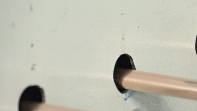 In close-up view, sophisticated machine skillfully shapes copper tubes for industrial air conditioning. Slow motion showcases precise movements and mesmerizing details of this manufacturing process.