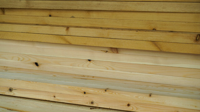 Horizontal stack of natural pine wood planks and lumber