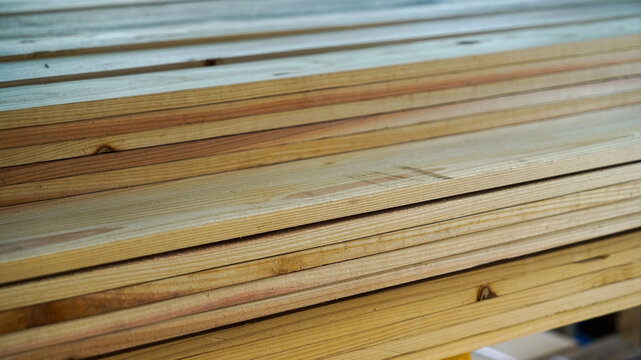 Horizontal stack of raw pine wood planks and lumber