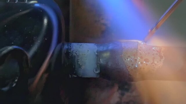 In a vibrant workshop filled with warmth, skilled hands shape glowing metal using a torch. Sparks fly as creativity flows, showcasing the delicate dance between fire and craftsmanship in action.