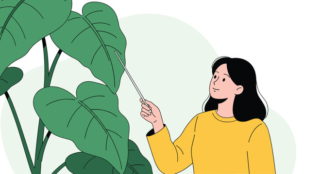 Young female botanist holding pointer stick and presenting big green leaf of tropical indoor houseplant.