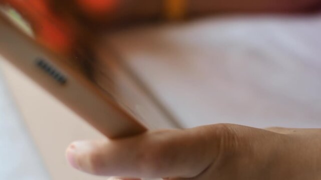 Child controls mobile game with one finger on touchscreen tablet during digital play, leisure and entertainment at home.
