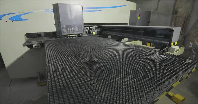 Industrial Metal Sheet Punching on CNC Machine. CNC Metal Fabrication with Turret Punch Press. Close-up of the coordinate punching machine's work table.