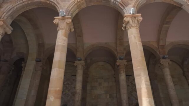 Walk through the beautiful stone colonnade of the historic Jermuk Mineral Water Gallery in Armenia, showcasing classical architecture with elegant arches and columns on a bright sunny day.

