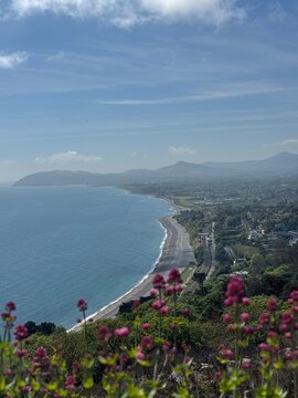 Vista a&eacute;rea da linha costeira com praia, montanhas e oceano azul, paisagem natural de grande beleza.