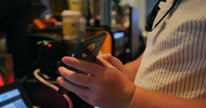 Contactless mobile payment using smartphone and card at coffee shop counter, barista hands tapping terminal during checkout in warm cafe interior while ordering drinks near counter area