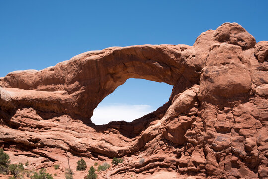 South Window Arch in Arches National Park, Moab, UT, USA on a summer day, blue sky. View of South Window Arch and surrounding red rock formations.