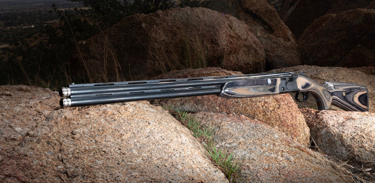 12 gauge double barreled shotgun outdoors on large boulders