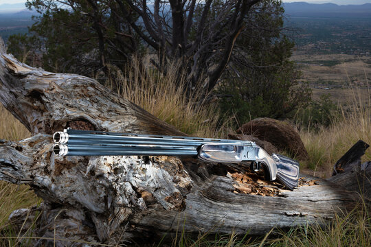 Over and under double barrel shotgun at a scenic outlook in the mountains