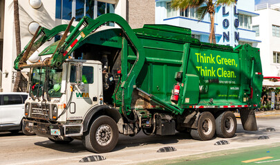 Fototapeta premium Miami, Florida, USA - December 09, 2024: Garbage truck Think green. Waste management industry. Sorting and recycling concept. Garbage collection service. Waste collection truck
