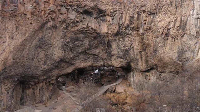 Aerial drone footage capturing the magnificent Devil's Bridge and Vorotan River Canyon in Armenia, showcasing the unique natural rock formations, towering steep cliffs,and winding scenic mountain road