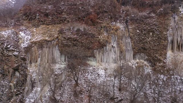 Aerial drone footage capturing the magnificent Devil's Bridge and Vorotan River Canyon in Armenia, showcasing the unique natural rock formations, towering steep cliffs,and winding scenic mountain road