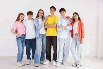 Fototapeta premium Portrait of happy teenagers near white wall indoors