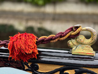 Brass Fish, rope and red pompom detail on a gondola in Venice Italy © SS