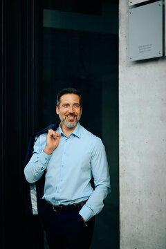 Portrait of confident businessman outside the office looking away.
